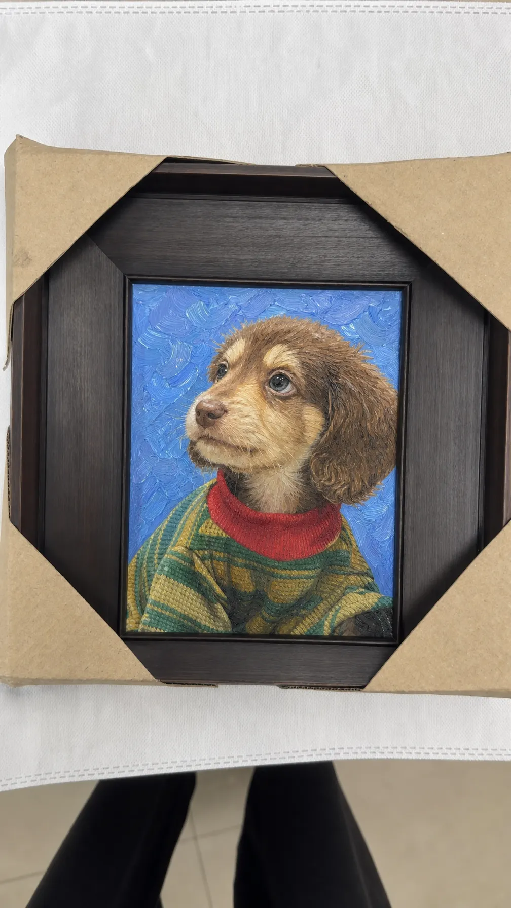 Unboxing the framed pet portrait from craft paper packaging